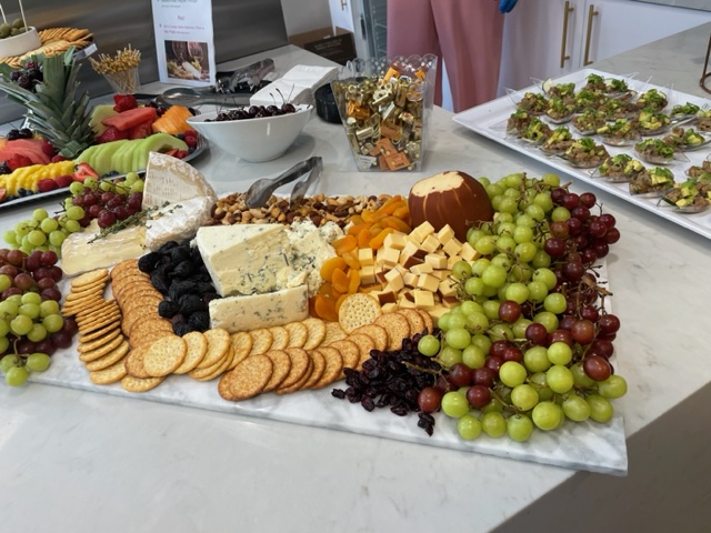 A delicious assortment of cheeses, crackers and fruit on a buffet table